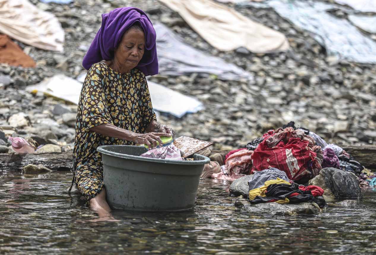 Penggunaan Sungai sebagai Sarana Mencuci Pakaian oleh Warga di Kawasan yang Belum Tersentuh Layanan Air Bersih