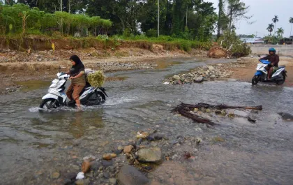 Berita Foto : Jembatan Diperbaiki, Warga Pilih Menyeberangi Sungai karena Jalan Alternatif Lebih Jauh