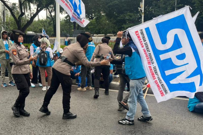 Terapkan Pendekatan Humanis, Polisi Bagikan Air Mineral dan Roti saat Demo Buruh di Jakarta