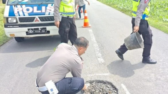 Satlantas Batu Bara Tambal Jalan Berlubang di Jalinsum un...
